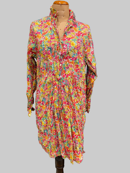 Colorful floral dress on a mannequin against a gray background