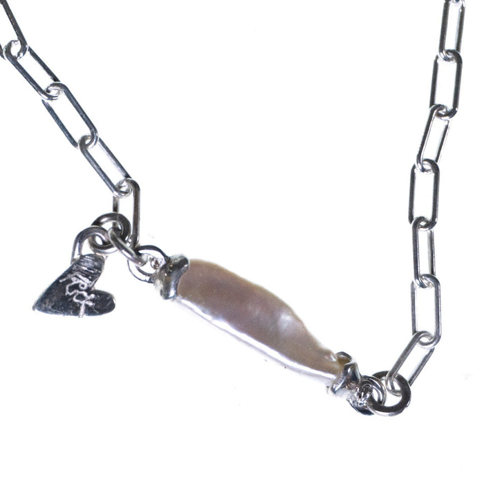 Metallic chain with a central object resembling a feather on a white background