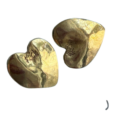 Two gold heart-shaped pendants on a blue textured background