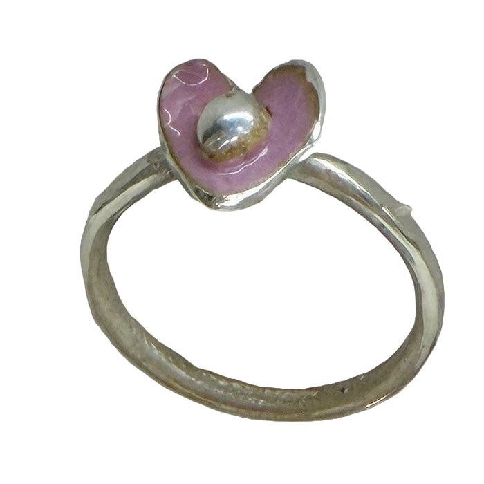 Silver ring with a pink heart-shaped gemstone on a light gray background