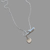 Silver necklace with a pendant on a wooden surface