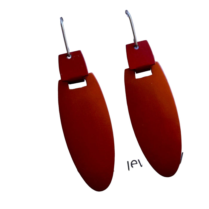 Pair of earrings with red and orange oval shapes on a white card with 'kalini jew' text.