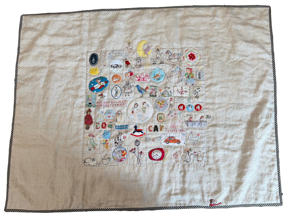 Embroidered patchwork design on a beige fabric background