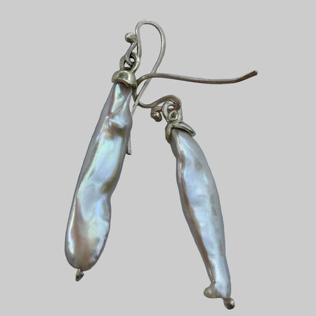 Pearl earrings on a gray surface
