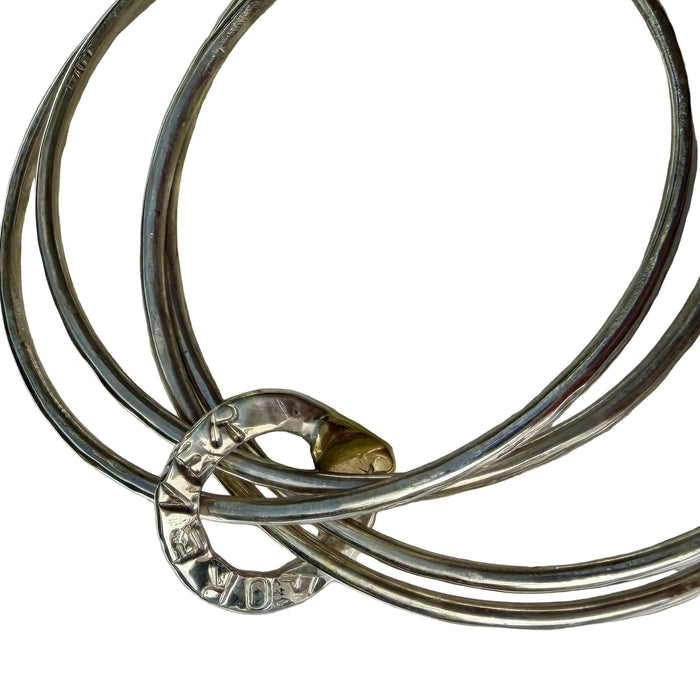 Set of silver bracelets on a textured surface