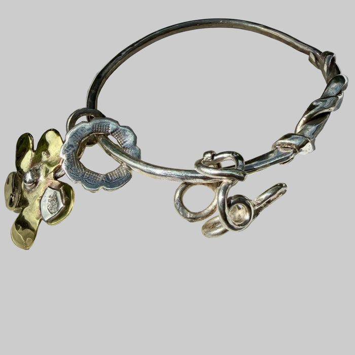 Silver bracelet with floral charms on a large shell