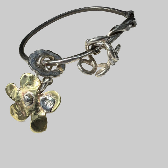 Silver bracelet with floral charms on a shell