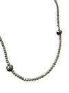 Pearl necklace with silver beads on a light gray background