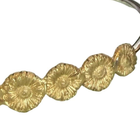 Gold headband on a light green wooden box with a blurred background