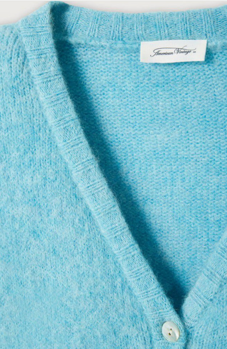 Close-up of the V neck and label on the American Vintage East cardigan in sky blue