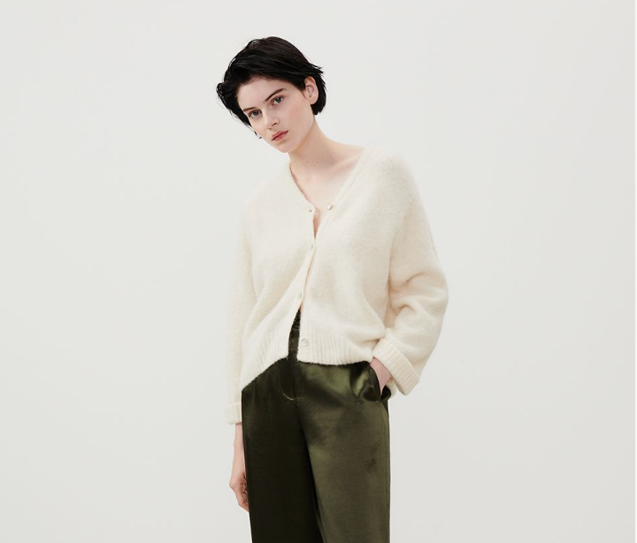 Model wearing the American Vintage cardigan in mother of pearl cream with green trousers