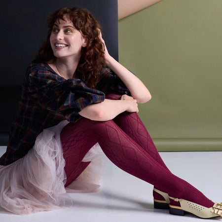Tightology claret Aran cashmere blend tights with cable knit pattern, styled with cream gold buckle heels