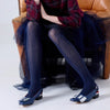 Tightology navy Aran cashmere blend tights with cable knit texture, paired with navy buckle heels
