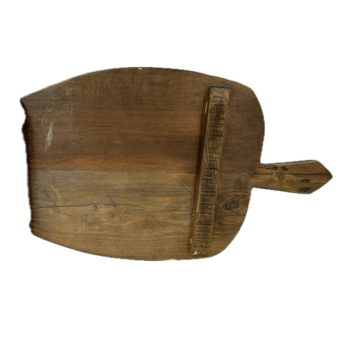 Wide dark vintage wooden bread board with a pointed handle, reverse side showing a nailed cross batten