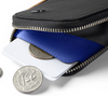 Bellroy Card Pocket wallet in black with cobalt lining, open with cards and coins
