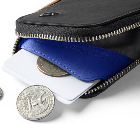 Bellroy Card Pocket wallet in black with cobalt lining, open with cards and coins