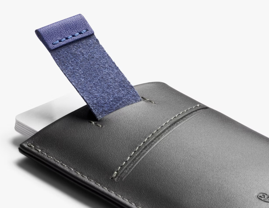 Bellroy Card Sleeve wallet in charcoal/cobalt, pulling cards out with the tab