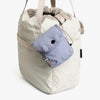 Bellroy Cinch Pocket in lilac haze, clipped to the outside of a cream tote bag
