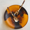 Dinosaur Designs Atelier resin salad bowl in amber with black swirl, top view with resin salad servers