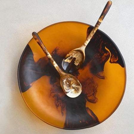 Dinosaur Designs Atelier resin salad bowl in amber with black swirl, top view with resin salad servers