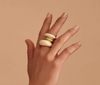 Dinosaur Designs Horn rings stacked on the finger, cream resin and gold