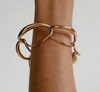 Dinosaur Designs Liquid chain bracelet in gold worn on the wrist
