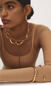 Dinosaur Designs Liquid chain choker and gold bangles worn by a model