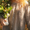 Close-up of the Etika brown gingham linen blouse showing the gathered round neckline and button front