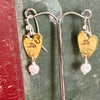 Flick Pope brass heart and pearl drop earrings on a stand