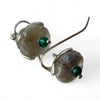 Close-up of a Flick Pope clear quartz earring with an aqua bead