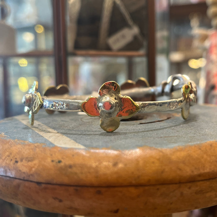 Flick Pope Daisy bangles, silver with brass daisies, displayed in store