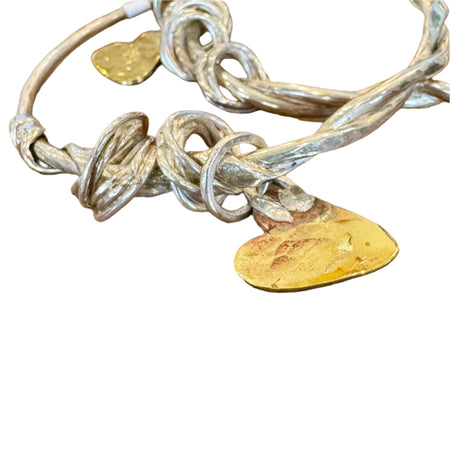 Flick Pope Doodad silver charm bangles stacked, with brass heart charms