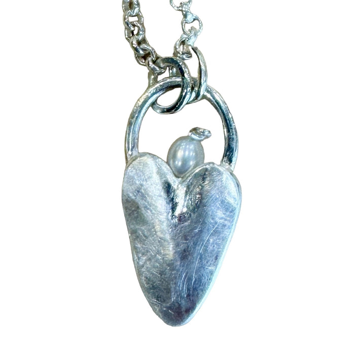 Close-up of the Flick Pope matt silver heart necklace with pearl