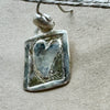 Close-up of a Flick Pope Postcard from the Heart earring, silver frame and heart