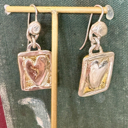 Flick Pope Postcard from the Heart earrings, brass hearts in silver frames, on a stand