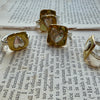 Flick Pope brass signet heart rings, a group on a book page