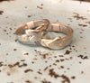 Two Flick Pope heart on side rings on a speckled surface