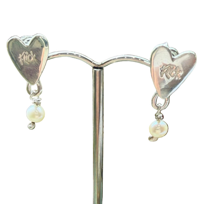 Flick Pope silver heart stud earrings with white pearl drops, on a stand
