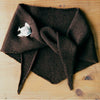 Francie Daisy scarf in chestnut, a solid brown knitted triangle neck scarf with tie ends and a fish brooch