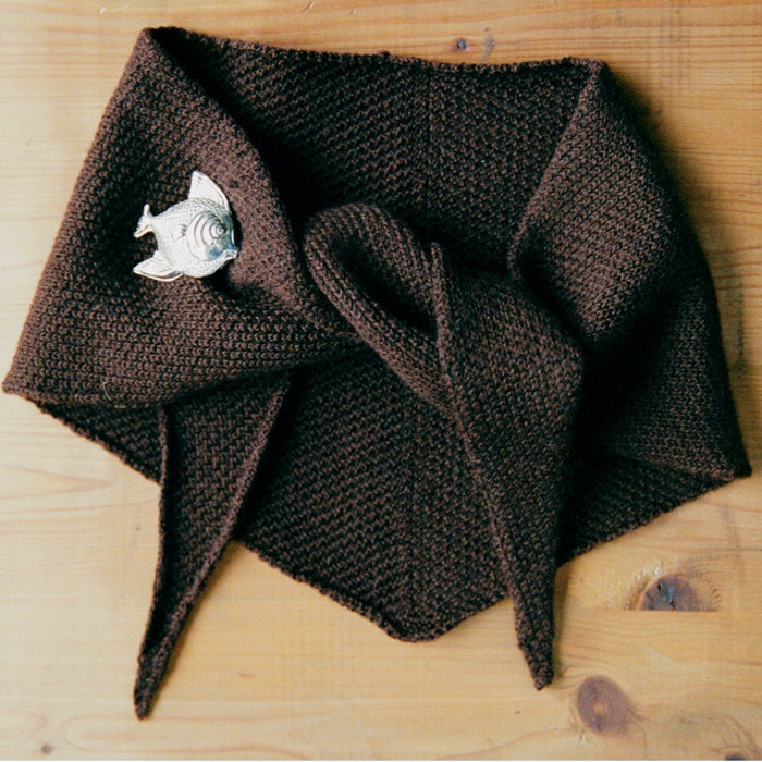 Francie Daisy scarf in chestnut, a solid brown knitted triangle neck scarf with tie ends and a fish brooch
