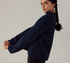 Francie Eclipse funnel neck jumper in black, side view with arms outstretched