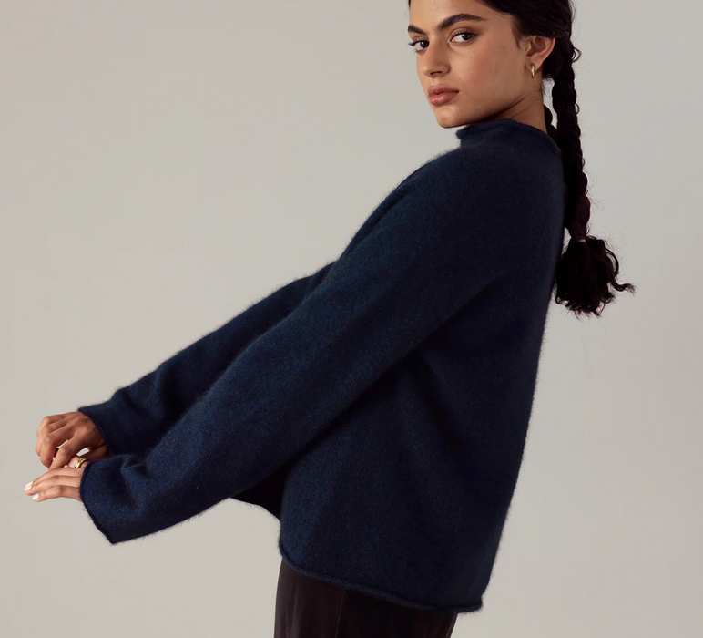 Francie Eclipse funnel neck jumper in black, side view with arms outstretched