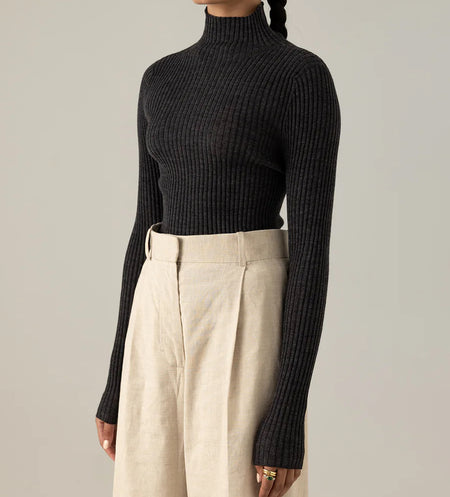 Francie Essence fine ribbed merino turtleneck in black, worn with cream trousers