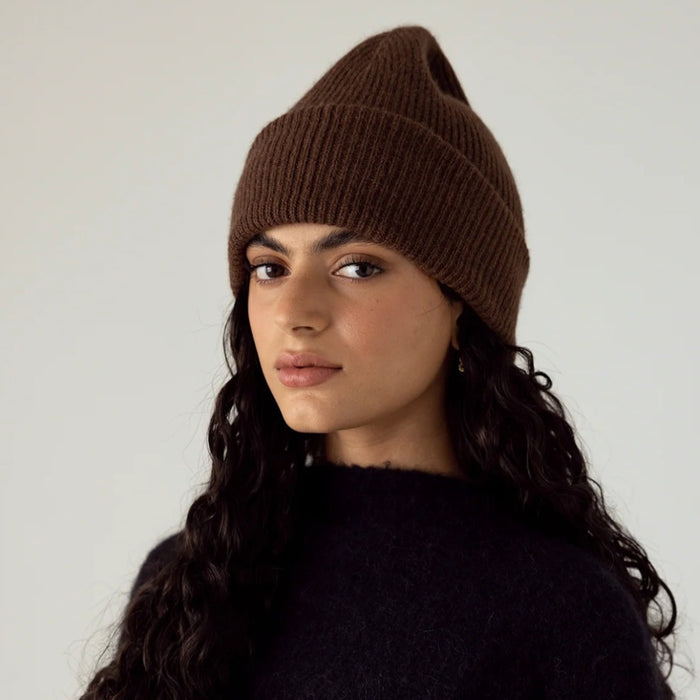 Francie Hinoki beanie in truffle brown, a ribbed knit beanie worn slouched with a black jumper