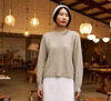 Francie Nimbus crew neck knit jumper in natural, worn in a cafe setting