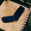 Francie possum merino socks in ink on chair
