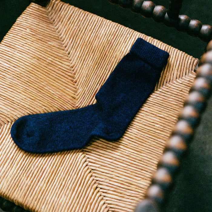 Francie possum merino socks in ink on chair