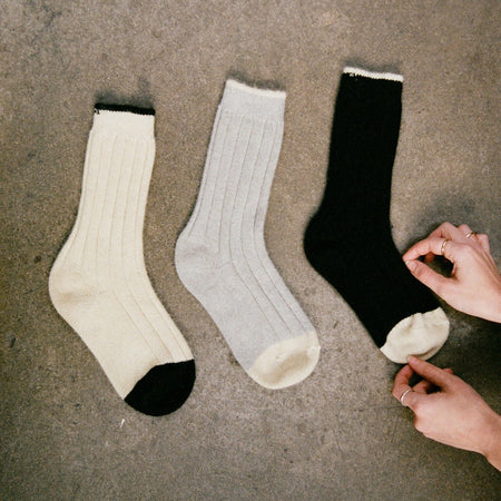 Francie Yin & Yang ribbed possum merino socks in three colourways — cream with black toe, grey, and black with cream toe