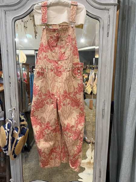 Free People Good Luck barrel overalls in pink lotus floral print, on a hanger