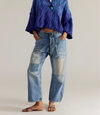 Free People Moxie low slung jeans in faded blue denim with patches, worn front